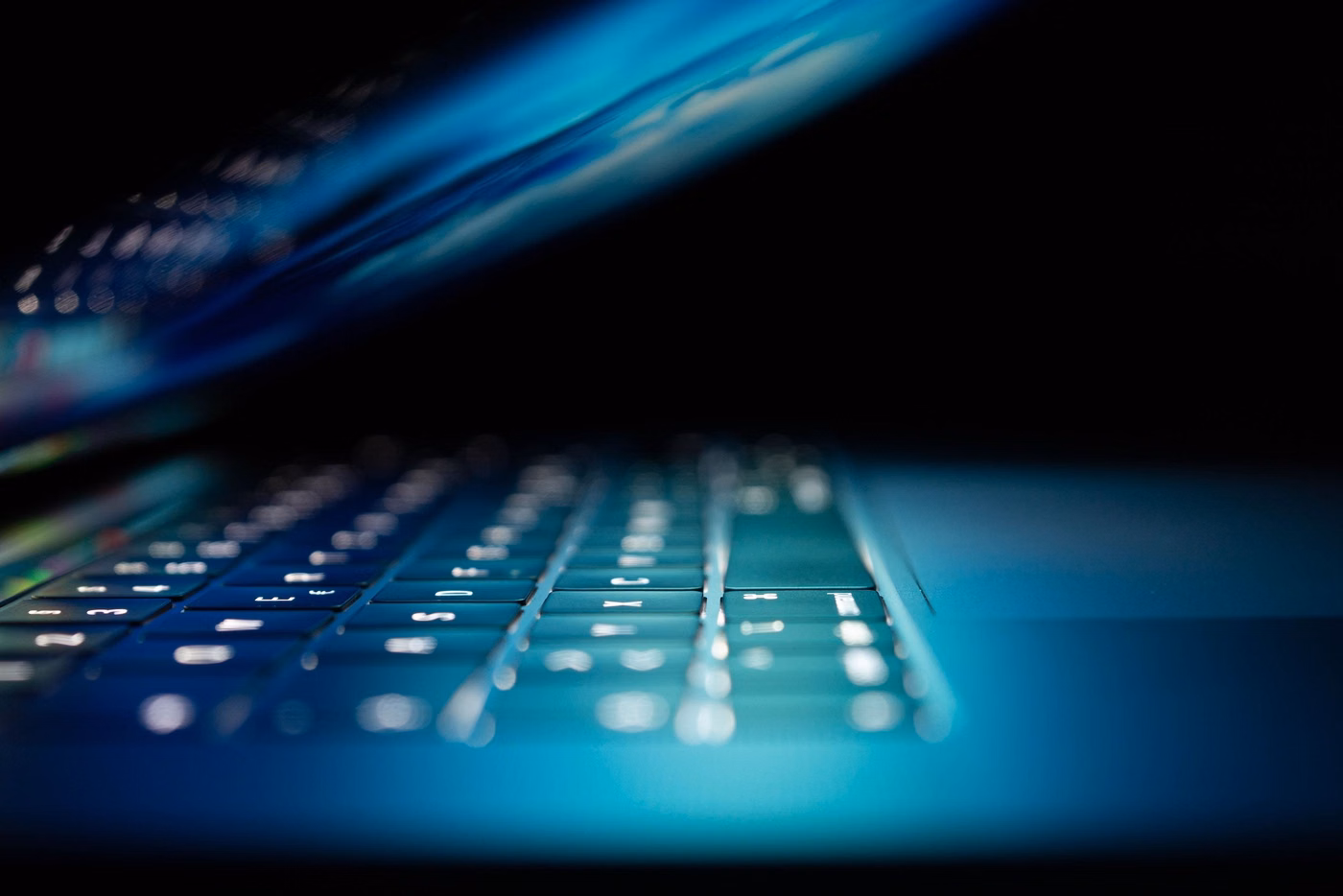 Close-up of partially closed laptop screen and keyboard